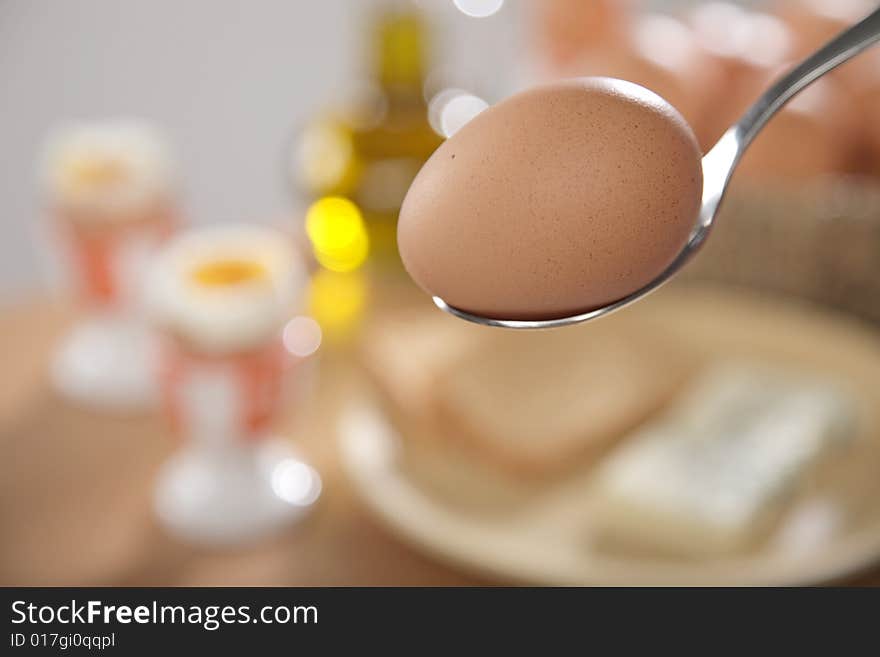 Breakfast table with toast bread and boiled eggs in cups in blur with windows reflections in the background. Breakfast table with toast bread and boiled eggs in cups in blur with windows reflections in the background.