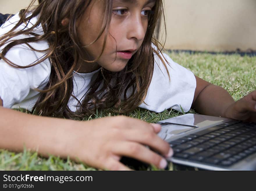 A lying little american boy playing with laptop