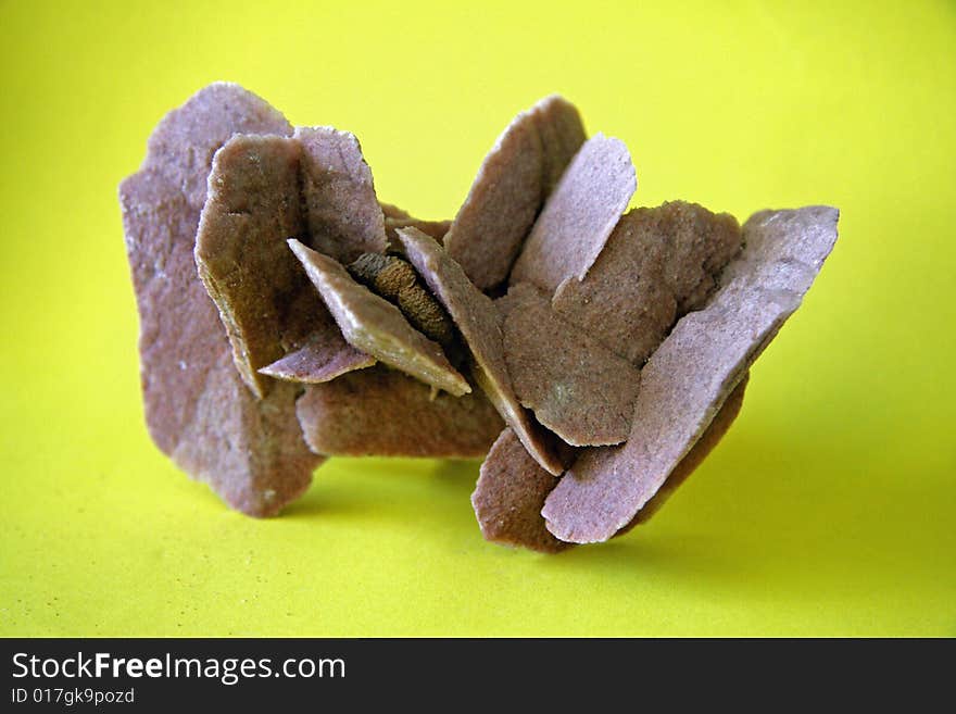 Mineral sample of gypsum, variety Desert Rose found in South Australia, with yellow background. Mineral sample of gypsum, variety Desert Rose found in South Australia, with yellow background.