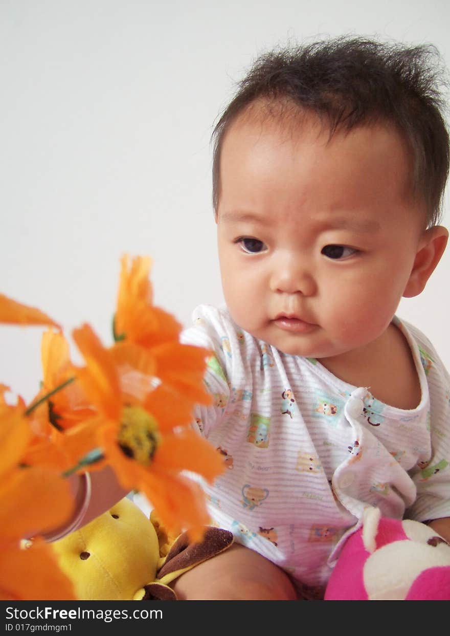 A cute baby and flowers. A cute baby and flowers