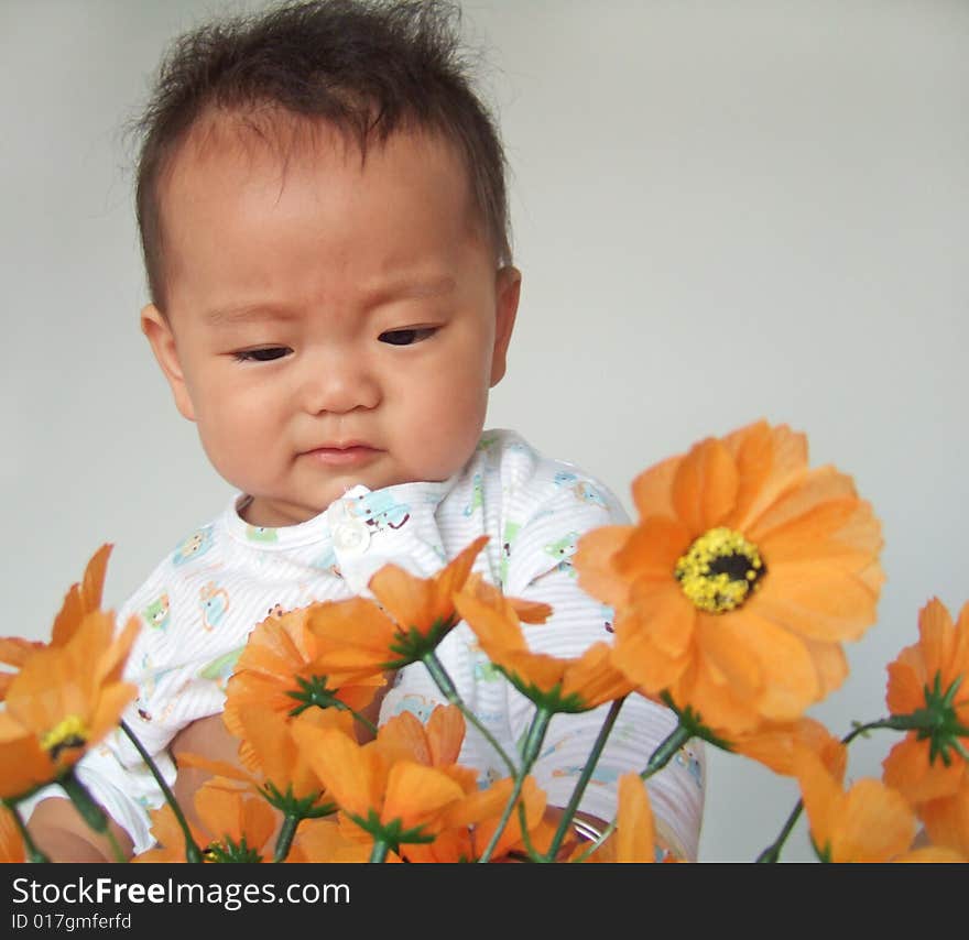 A cute baby and flowers. A cute baby and flowers