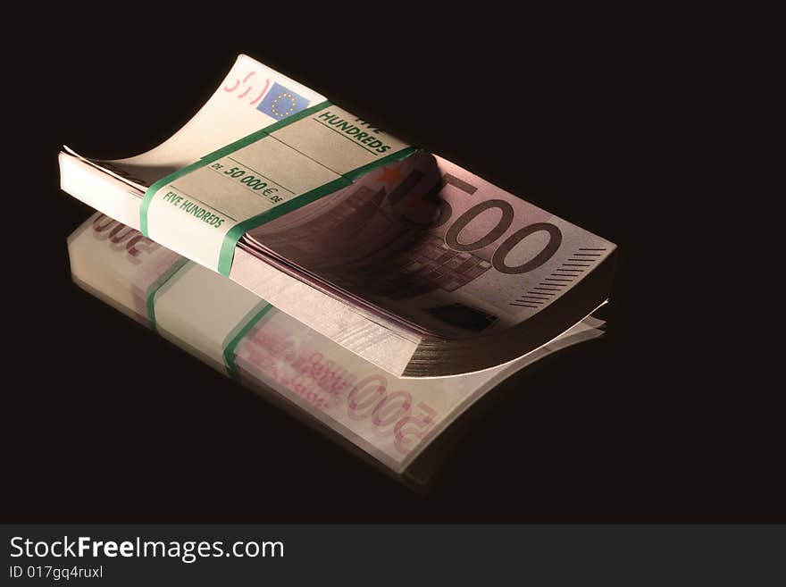 Bundle of euro bank notes lying on black background. Bundle of euro bank notes lying on black background