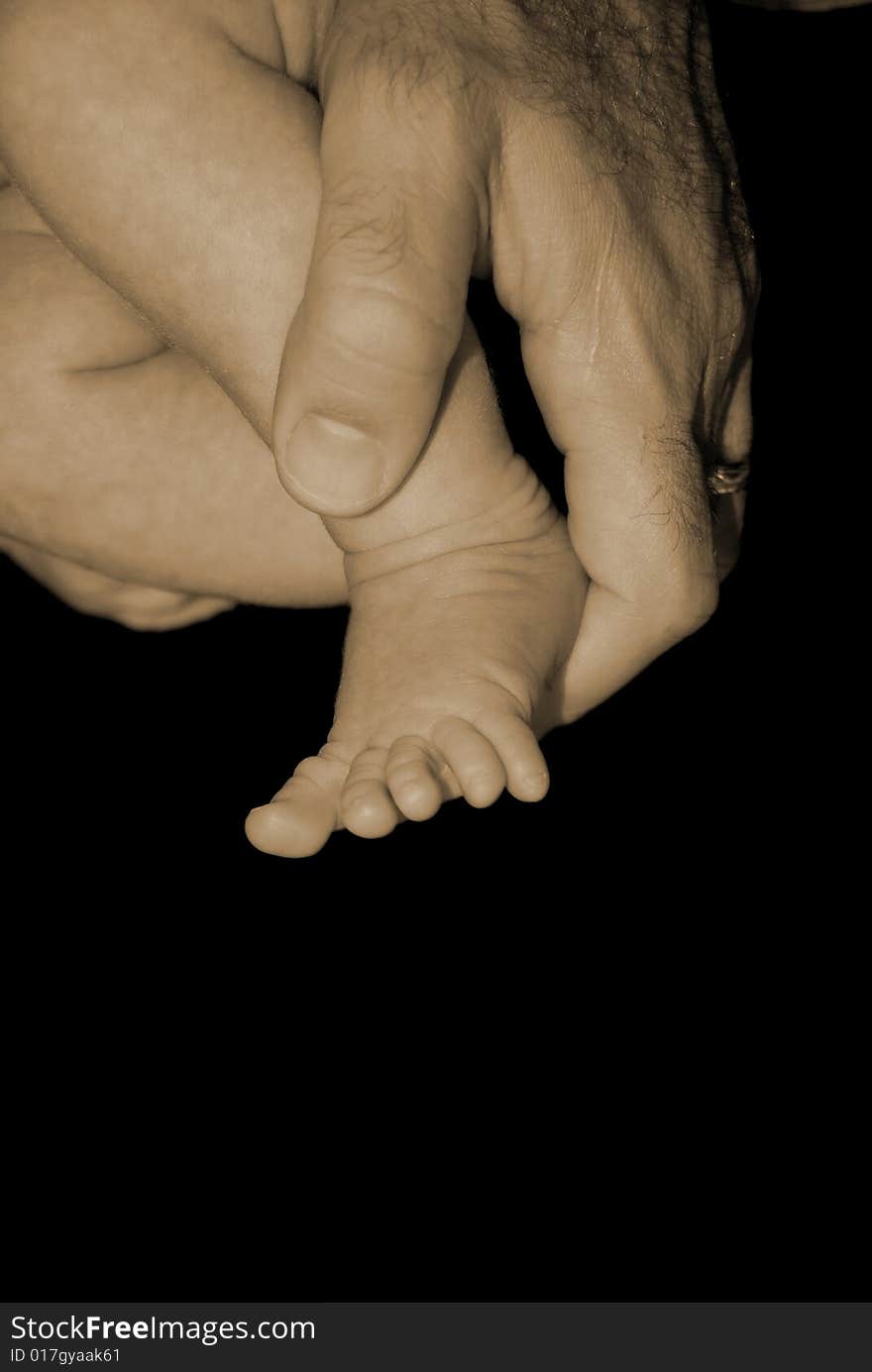 Father Holding Baby Newborns Foot. Father Holding Baby Newborns Foot