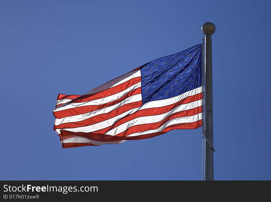 USA flag flutters over blur sky. USA flag flutters over blur sky