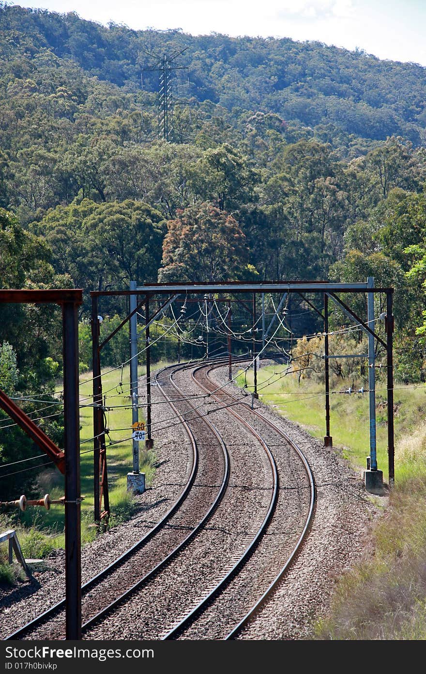 Twp pairs of railway tracks winding up through a section of heavily forested mountain. Twp pairs of railway tracks winding up through a section of heavily forested mountain.