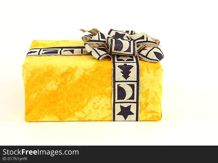 Christmas present in yellow original paper with beautiful tie