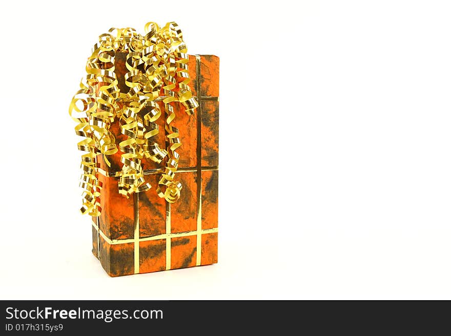 Orange christmas present with golden ties on white background