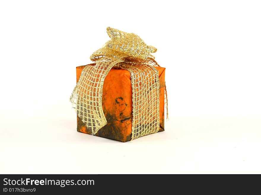 Small christmas present in orange paper with golden tie. Small christmas present in orange paper with golden tie