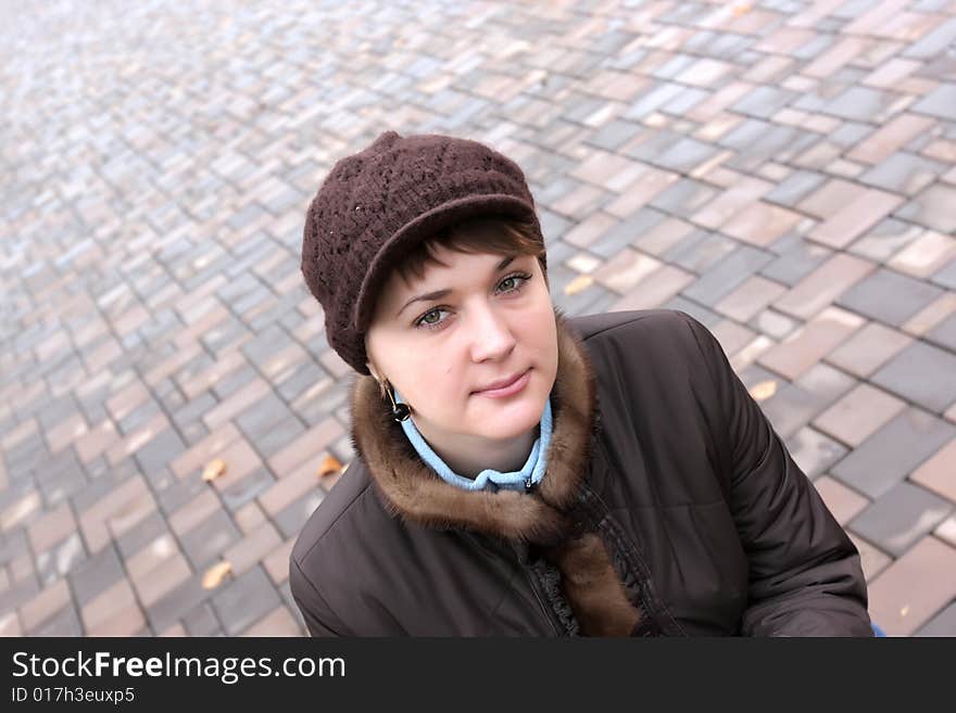 Autumnal portrait of young woman on sidewalk background