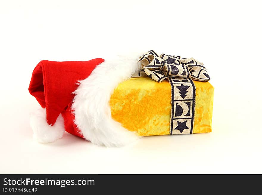 Yellow christmas present in santa's cap on white background