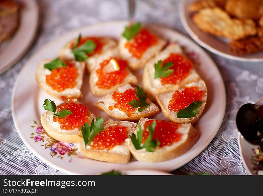 Small russian sandwiches with bread, butter and red caviar