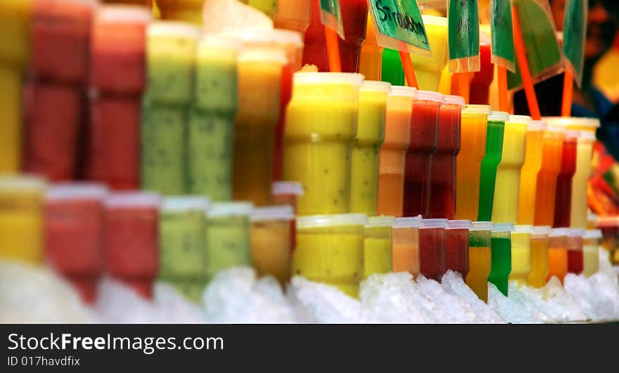 Different fresh fruit juices on a tropical fruit market