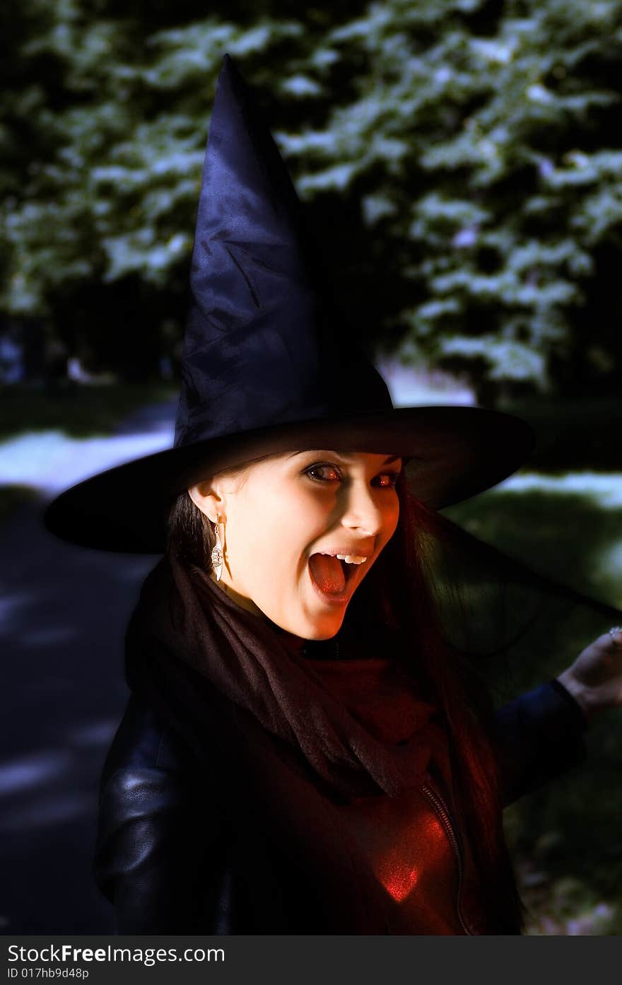 Screaming witch in a hat over darness