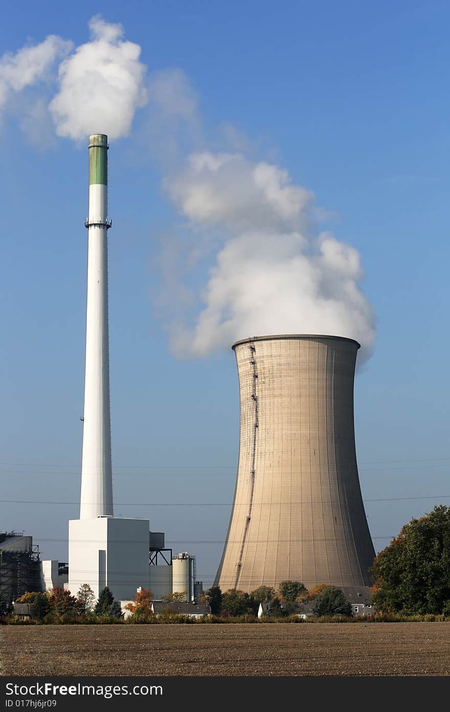 Smoke stacks of power station on blue sky