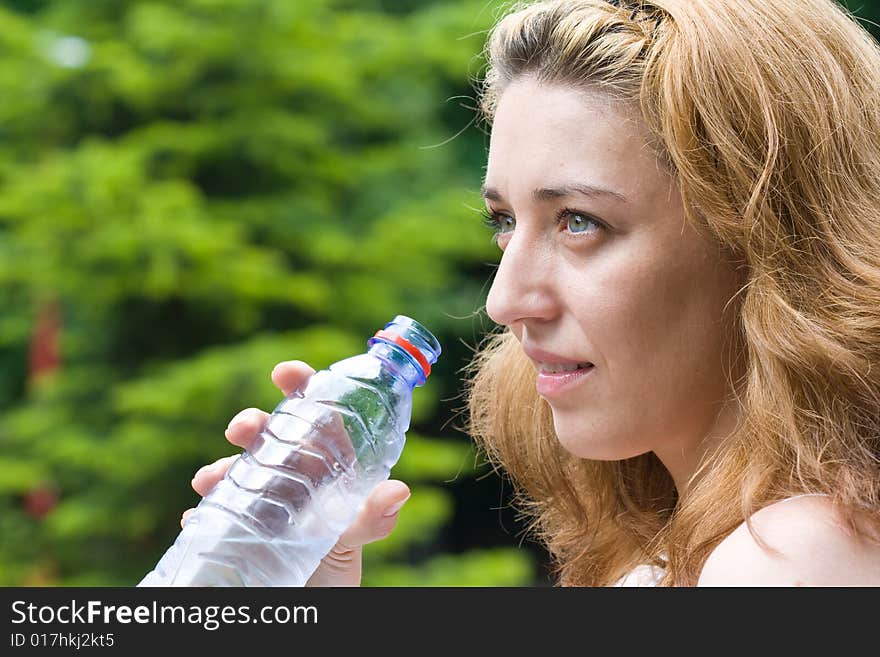 Pretty woman drinking water outdoors