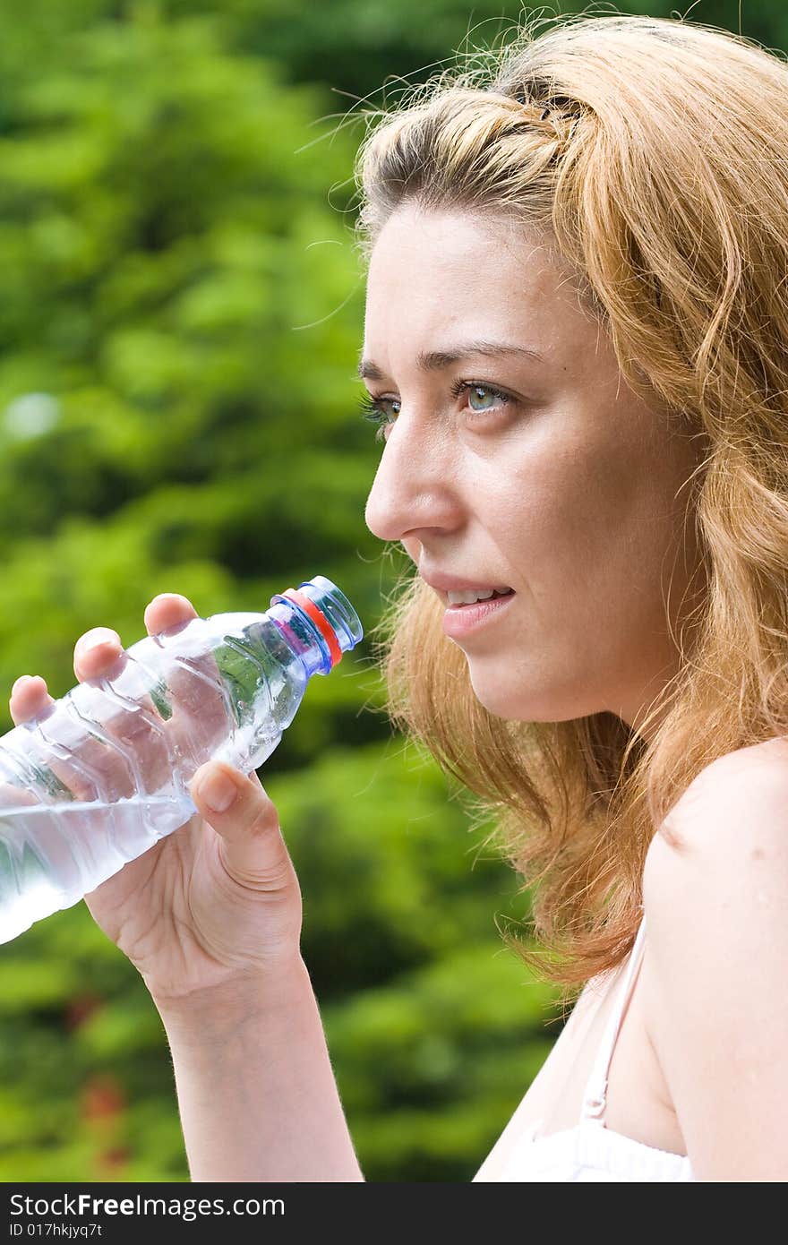 Pretty woman drinking water outdoors