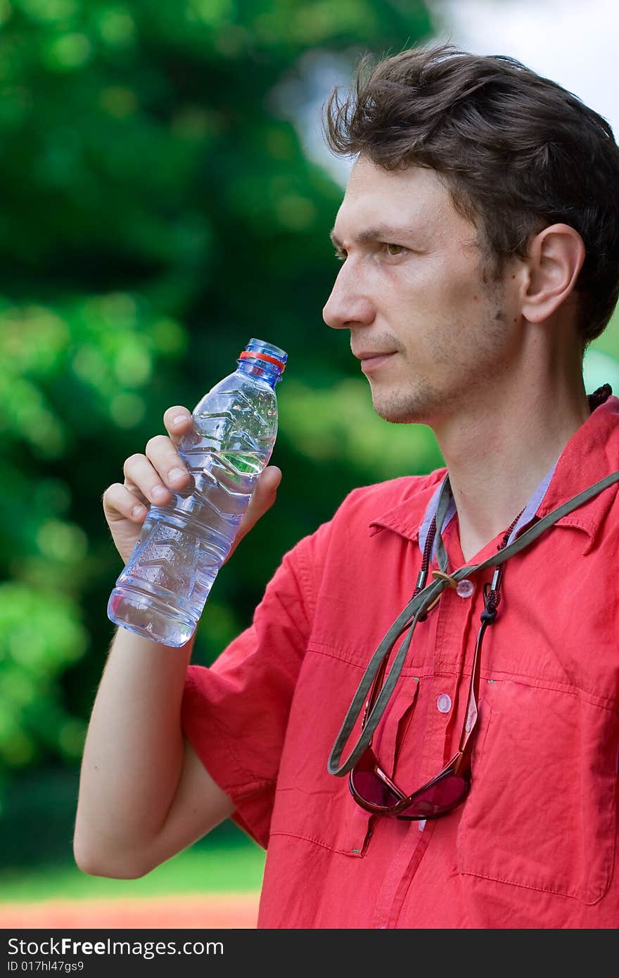 Man drinking water over a green background