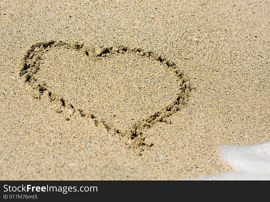 Heart written on wet sand