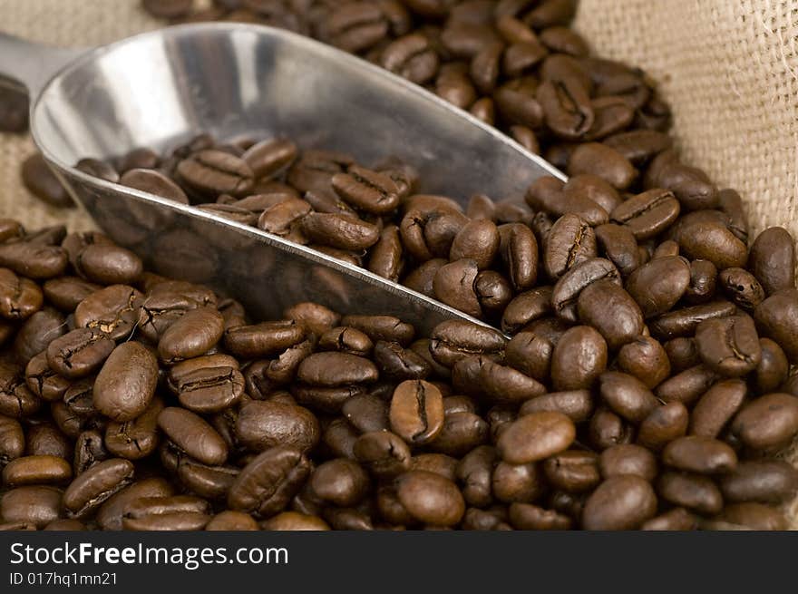 Coffee beans and silver shovel on canvas sack