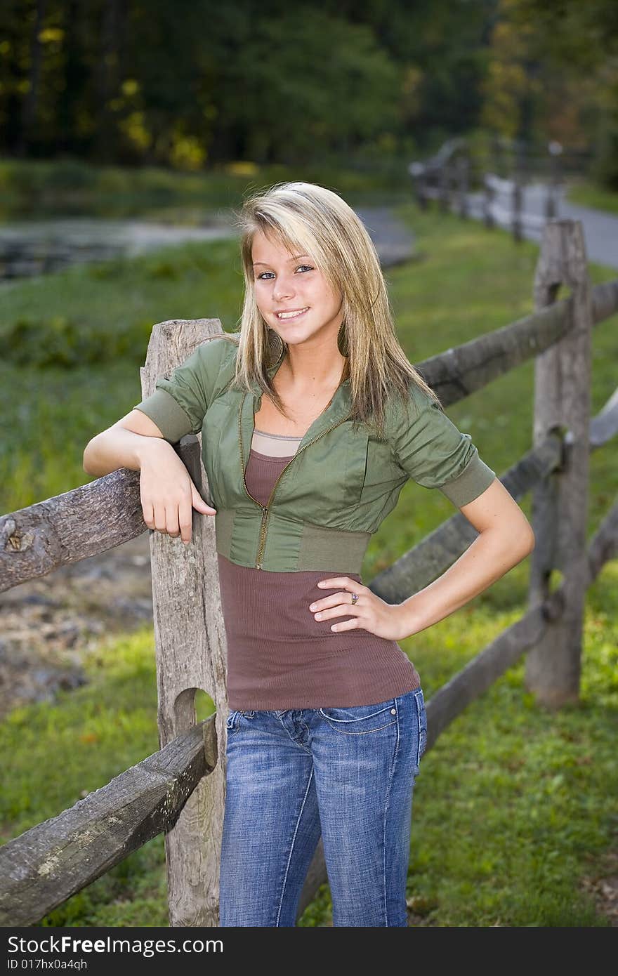 Beautiful young teenage girl leaning on a fence. Beautiful young teenage girl leaning on a fence