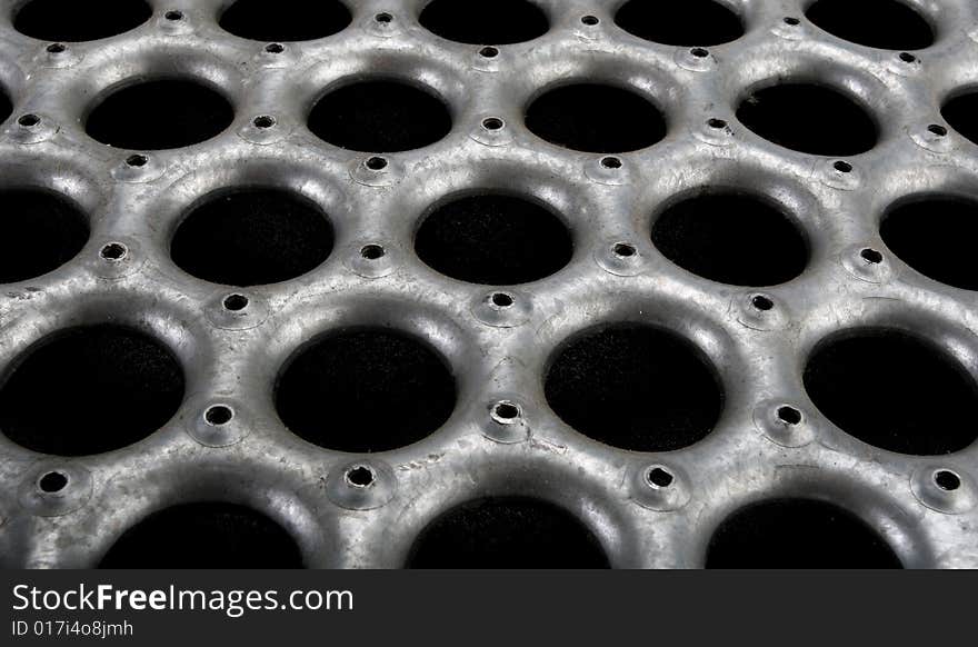 Grungy metal floor material close-up at an angle.