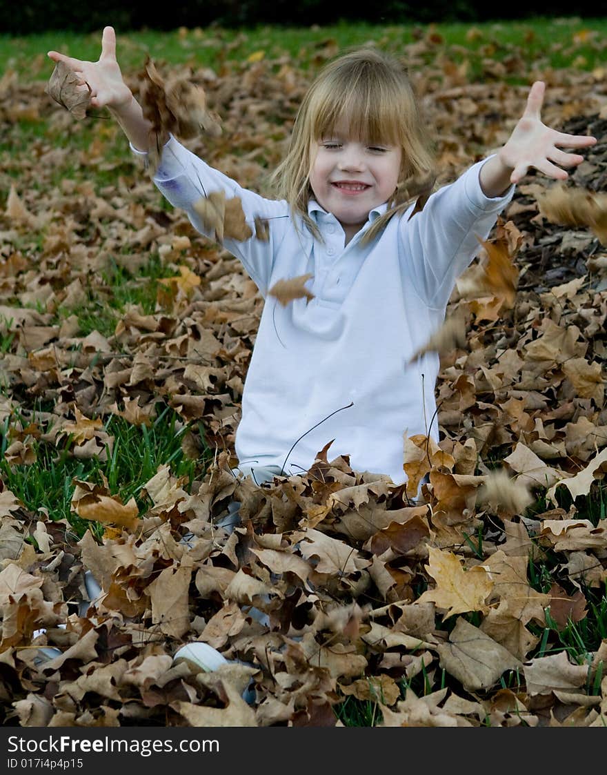 Four year old child playing in the autumn leaves. Four year old child playing in the autumn leaves