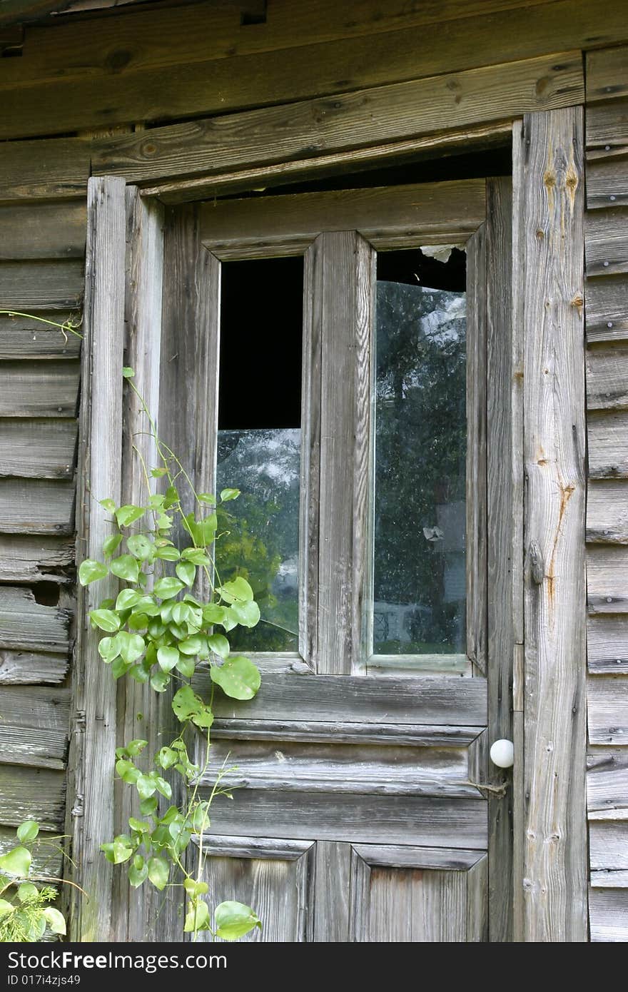 Wooden door with broken glass in a warped door frame. Wooden door with broken glass in a warped door frame