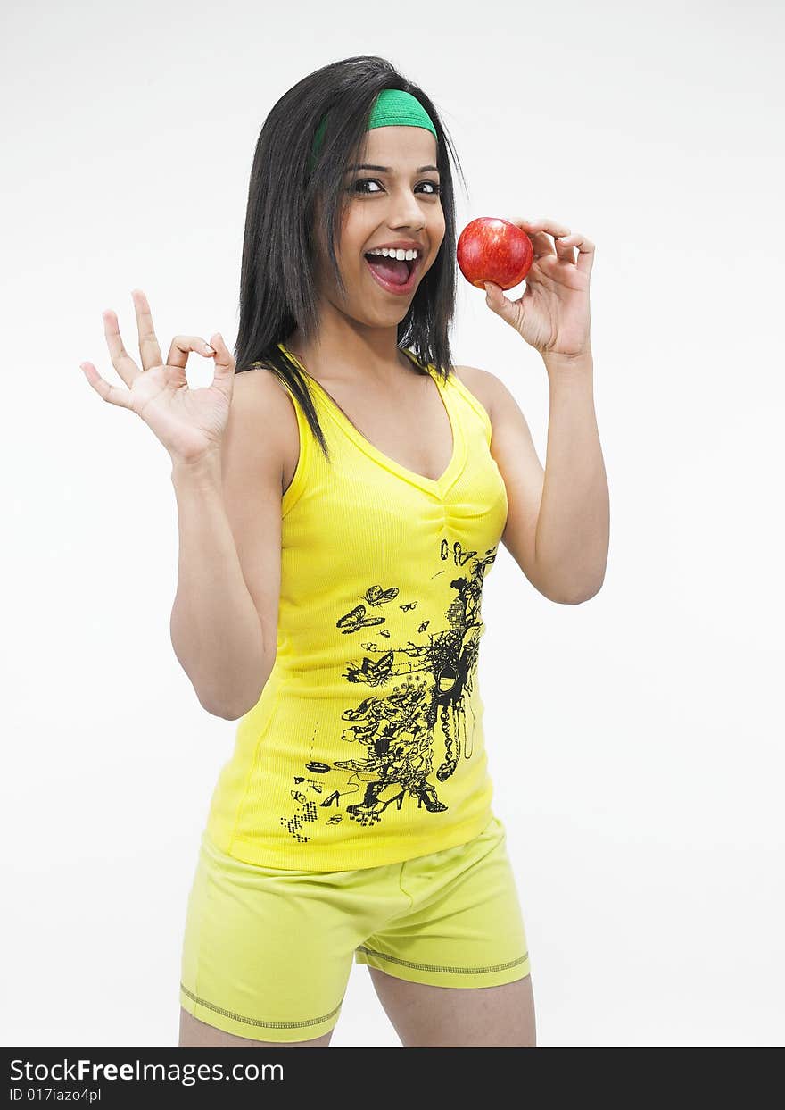 A asian girl of indian origin biting into a red apple. A asian girl of indian origin biting into a red apple