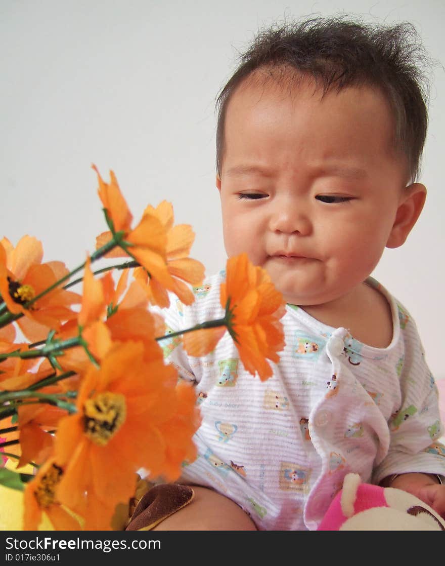 A cute baby and flowers. A cute baby and flowers