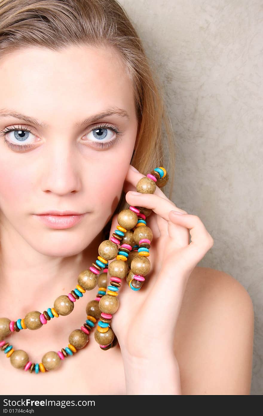 Beautiful female model with blue eyes and a string beads