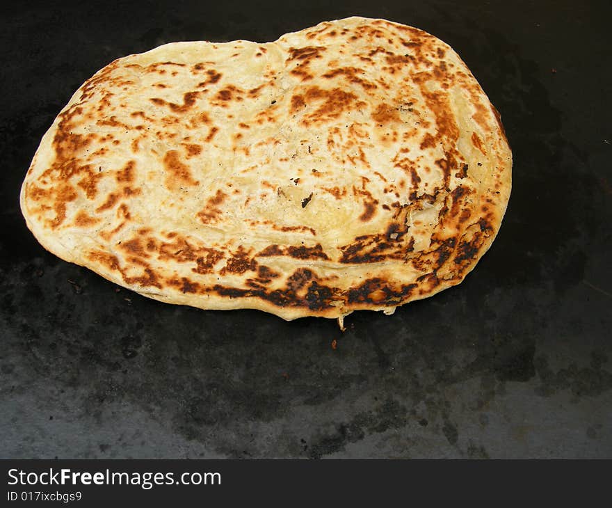 A freshly baked Italian flat bread on dark background. A freshly baked Italian flat bread on dark background