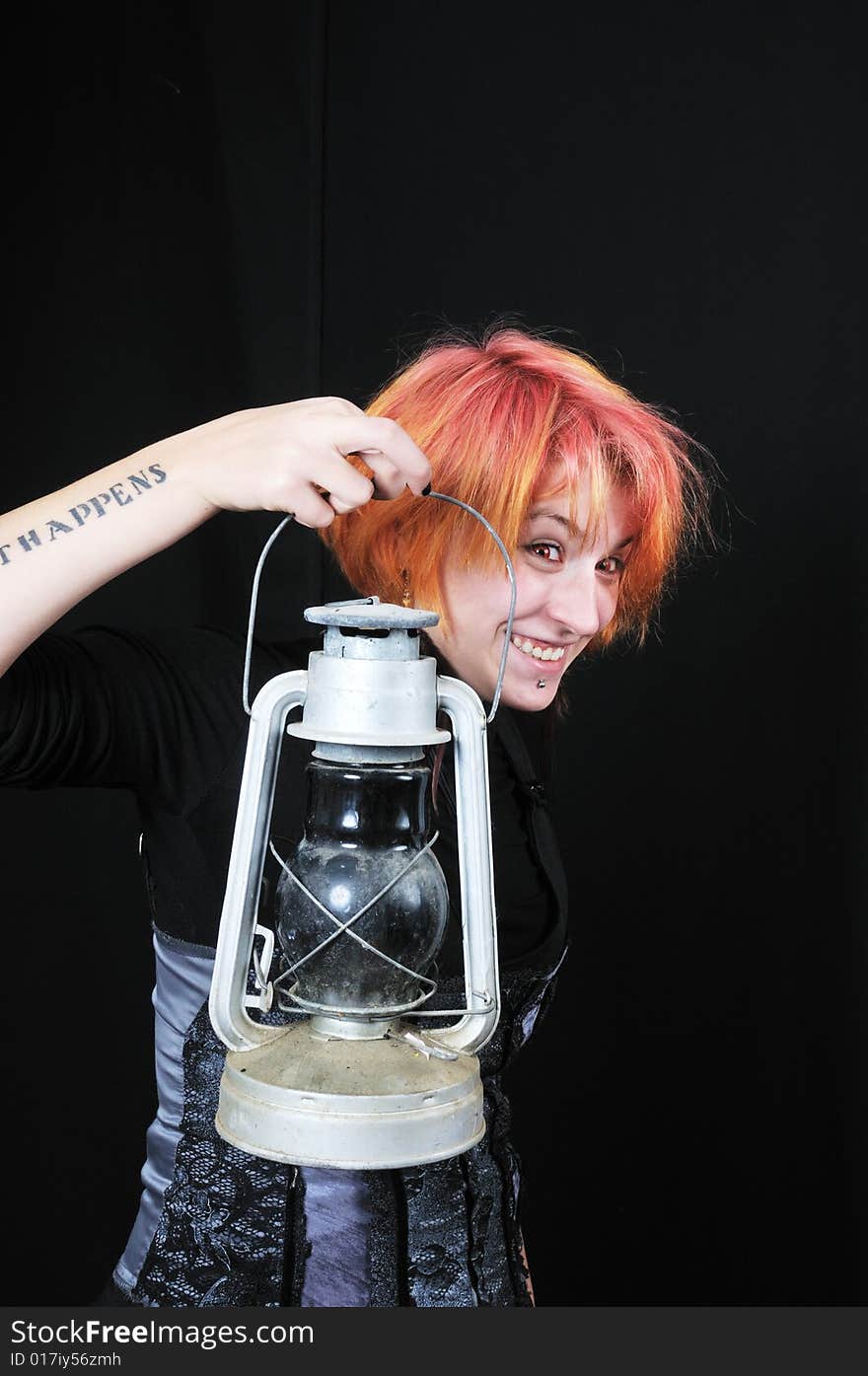 Happy red hair girl with lamp on black background