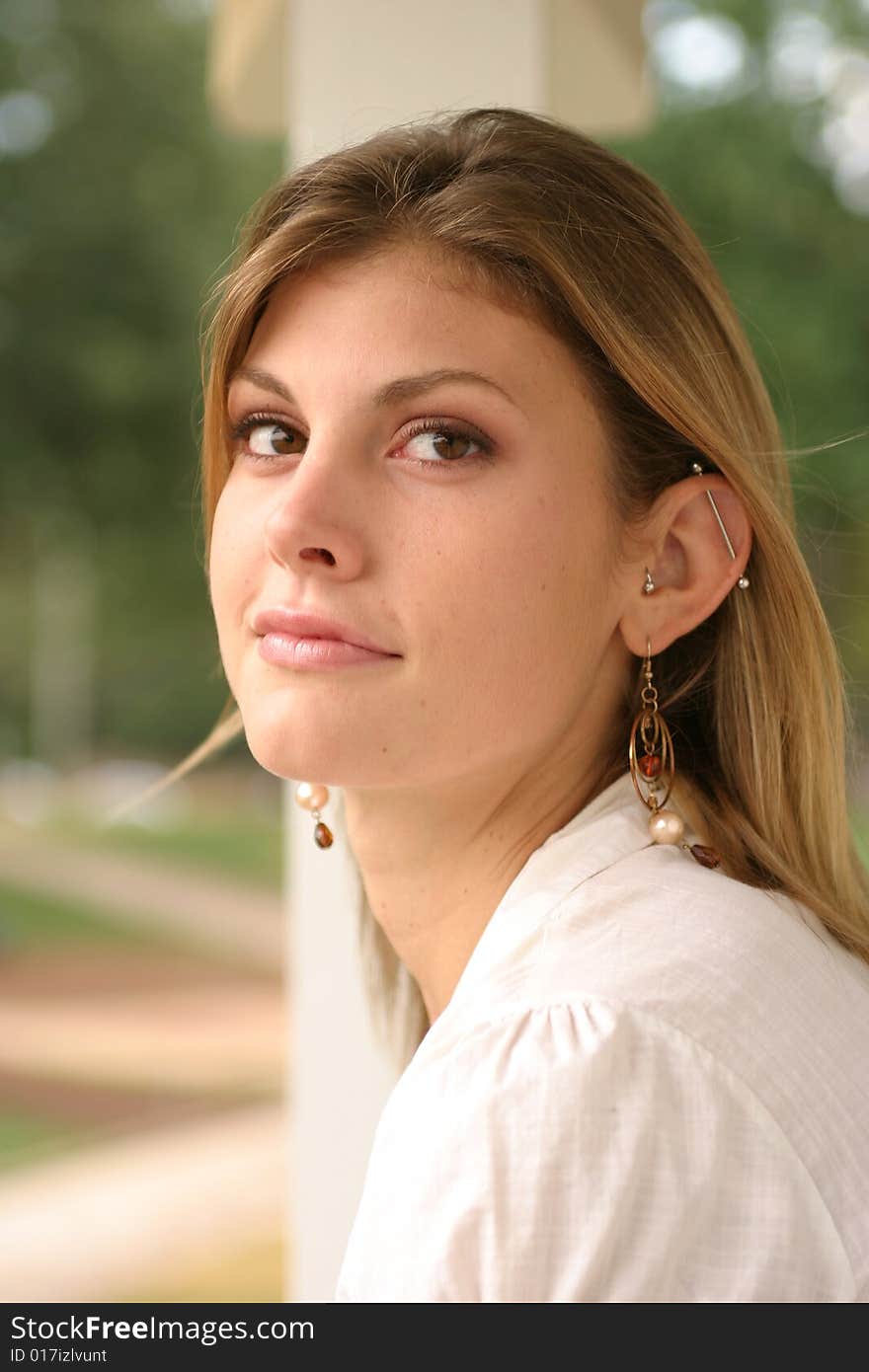 Young woman posing outside wearing a white top