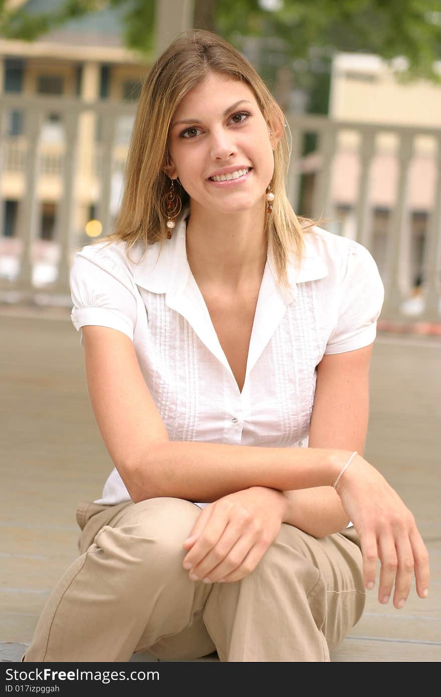 Young woman posing outside wearing a white top