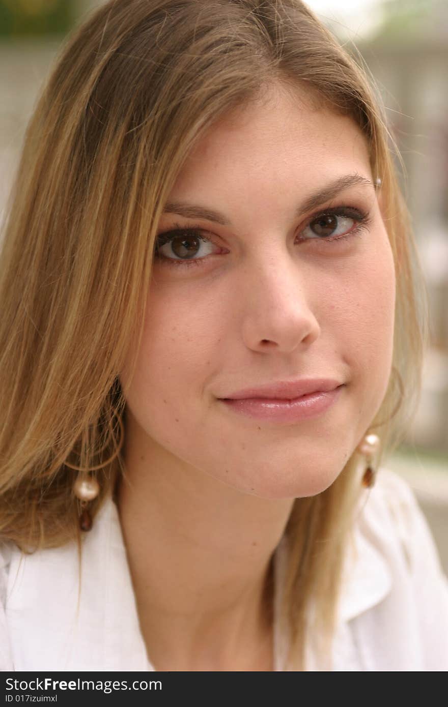 Young woman posing outside wearing a white top