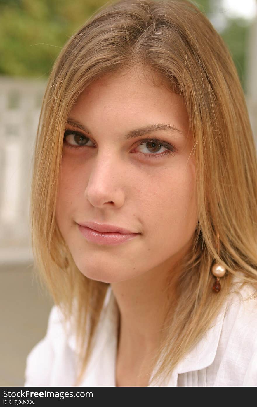 Young woman posing outside wearing a white top