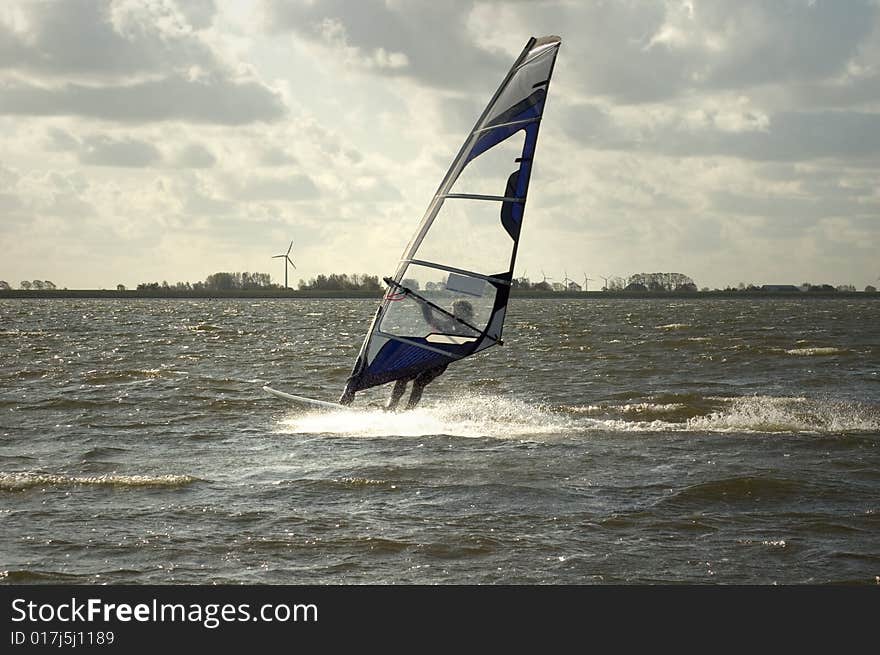 Speeding wind surfer in october backlight. Speeding wind surfer in october backlight