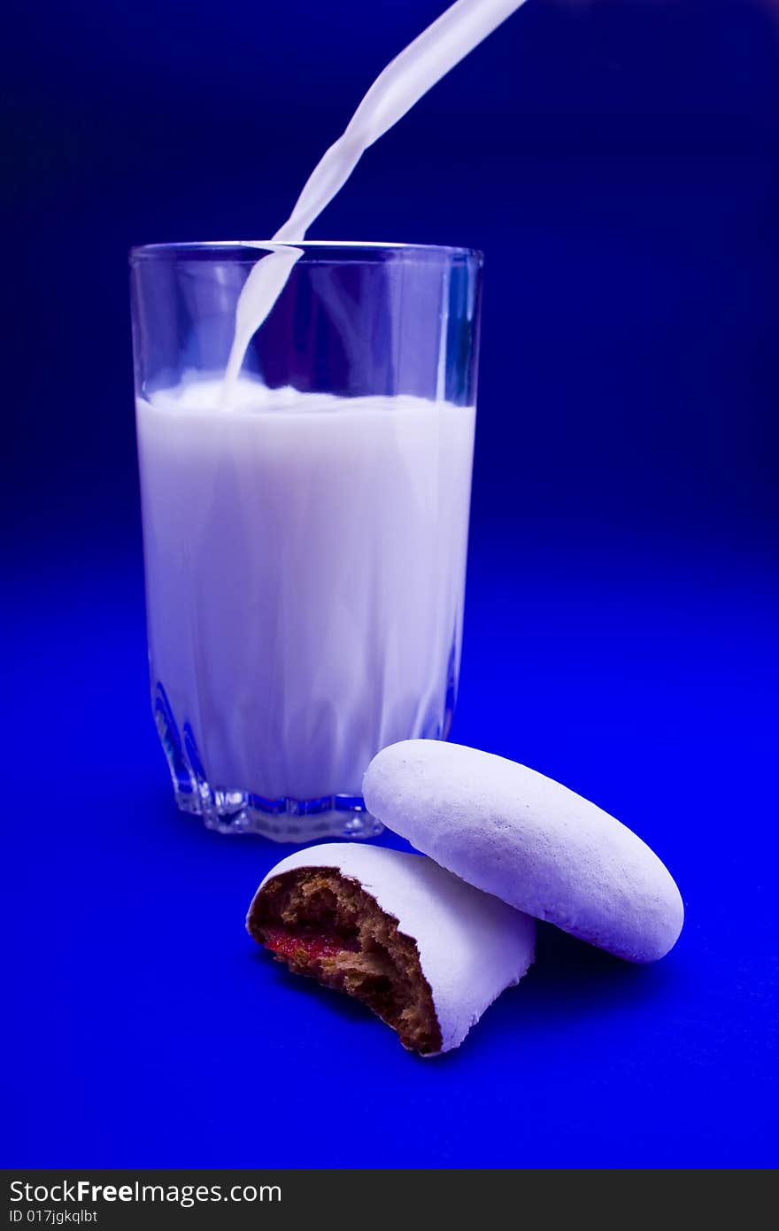 Cakes and glass of milk close-up isolated on violet background