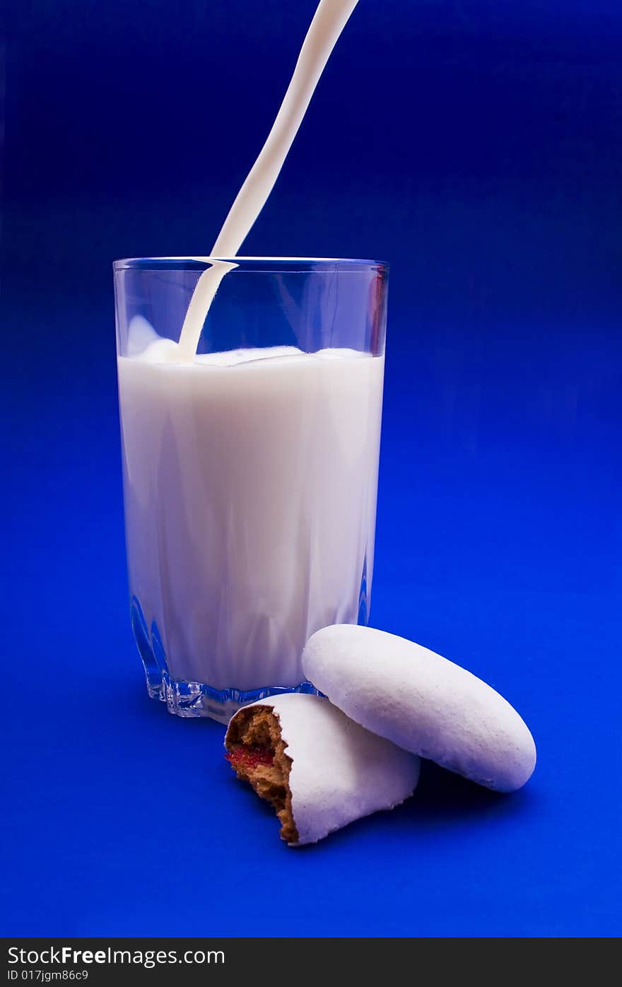 Cakes and glass of milk close-up isolated on violet background