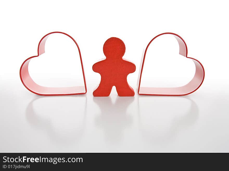 Red wooden person stands between red hearts. Isolated on white background. Red wooden person stands between red hearts. Isolated on white background.