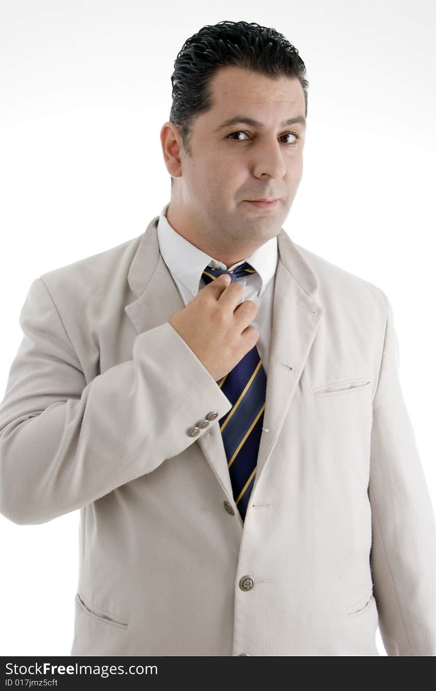 Businessman adjusting his tie and looking to camera on an isolated white background