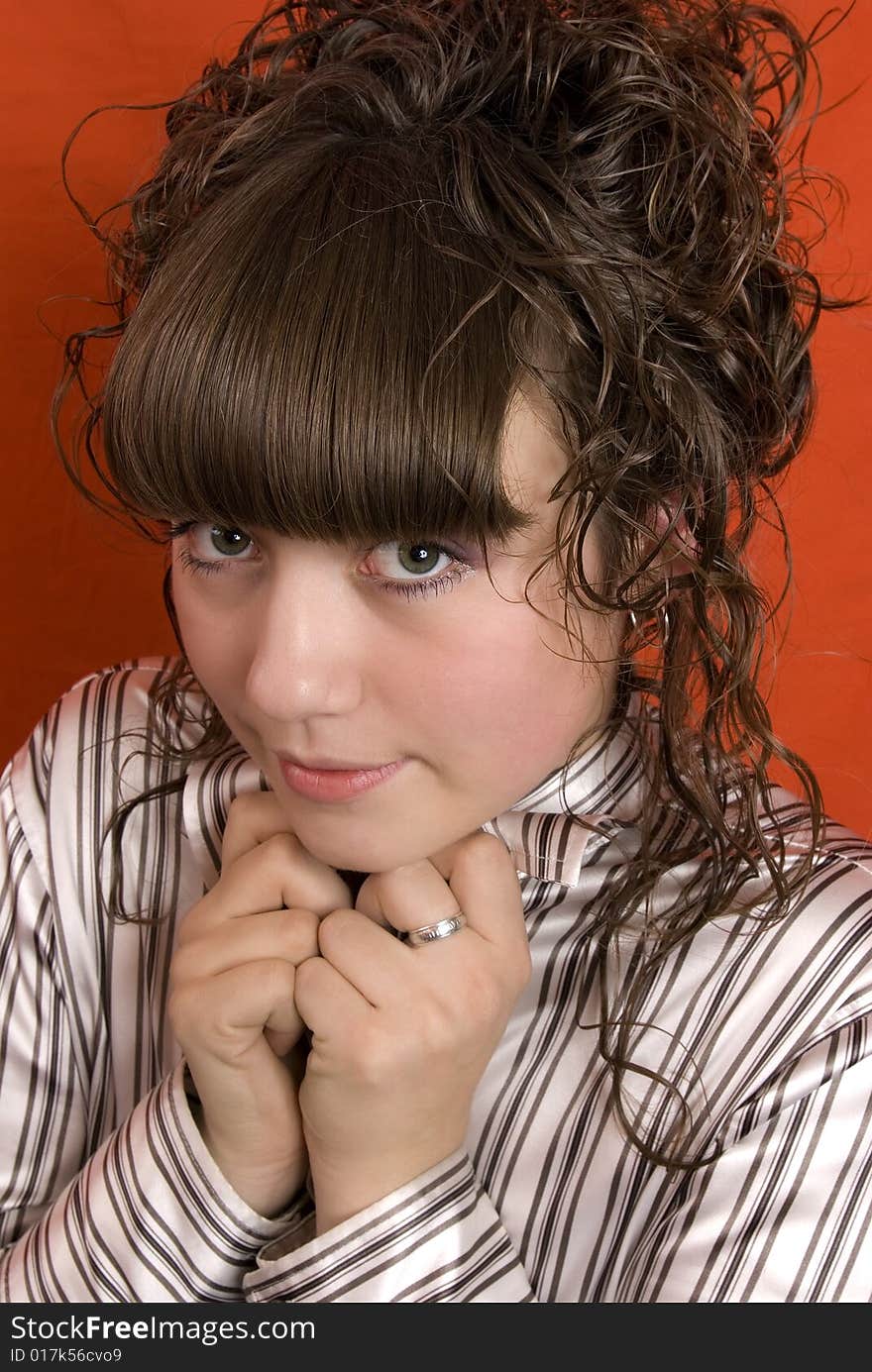 Timid girl with curly hair over red background