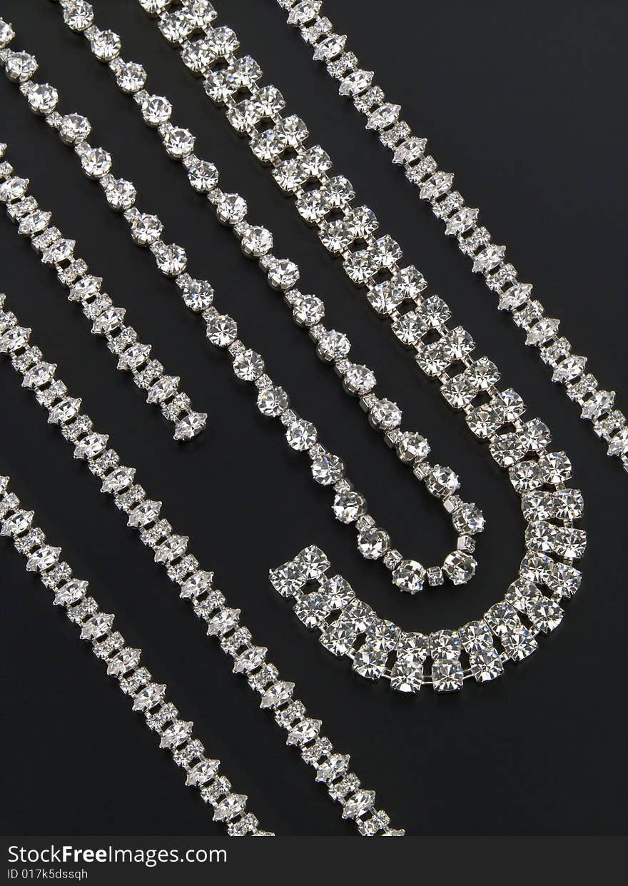 Display of silver necklaces and bracelets with shiny gemstones. Display of silver necklaces and bracelets with shiny gemstones