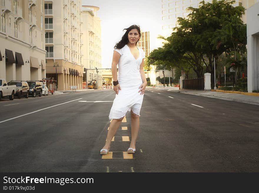 Young woman standing in the middle of an empty city street. Young woman standing in the middle of an empty city street.