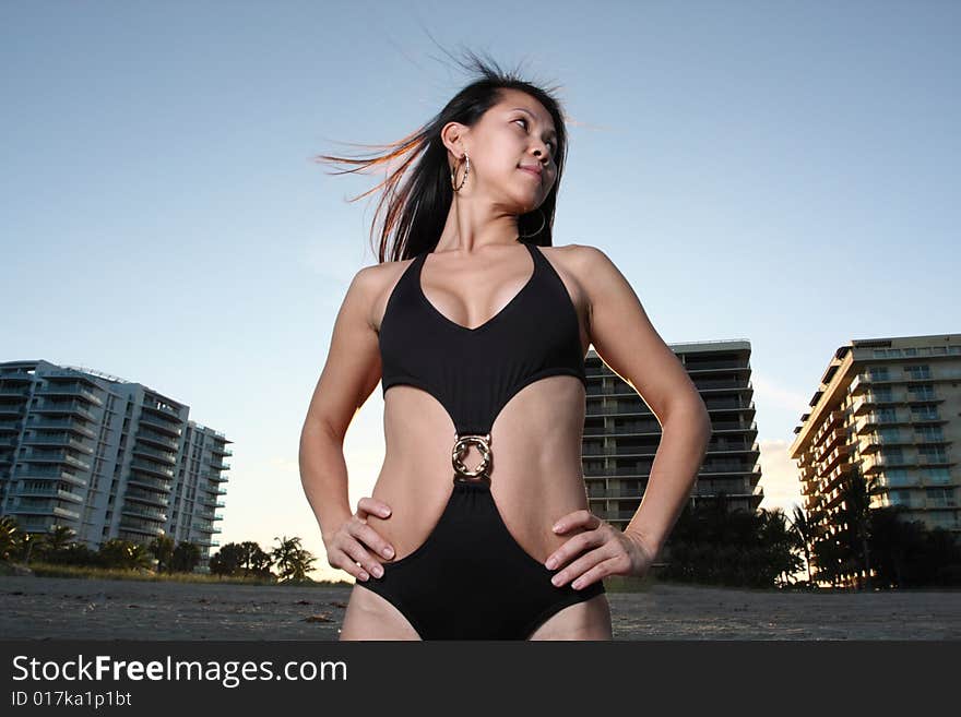 Young woman in a bikini at the beach during dusk. Young woman in a bikini at the beach during dusk.