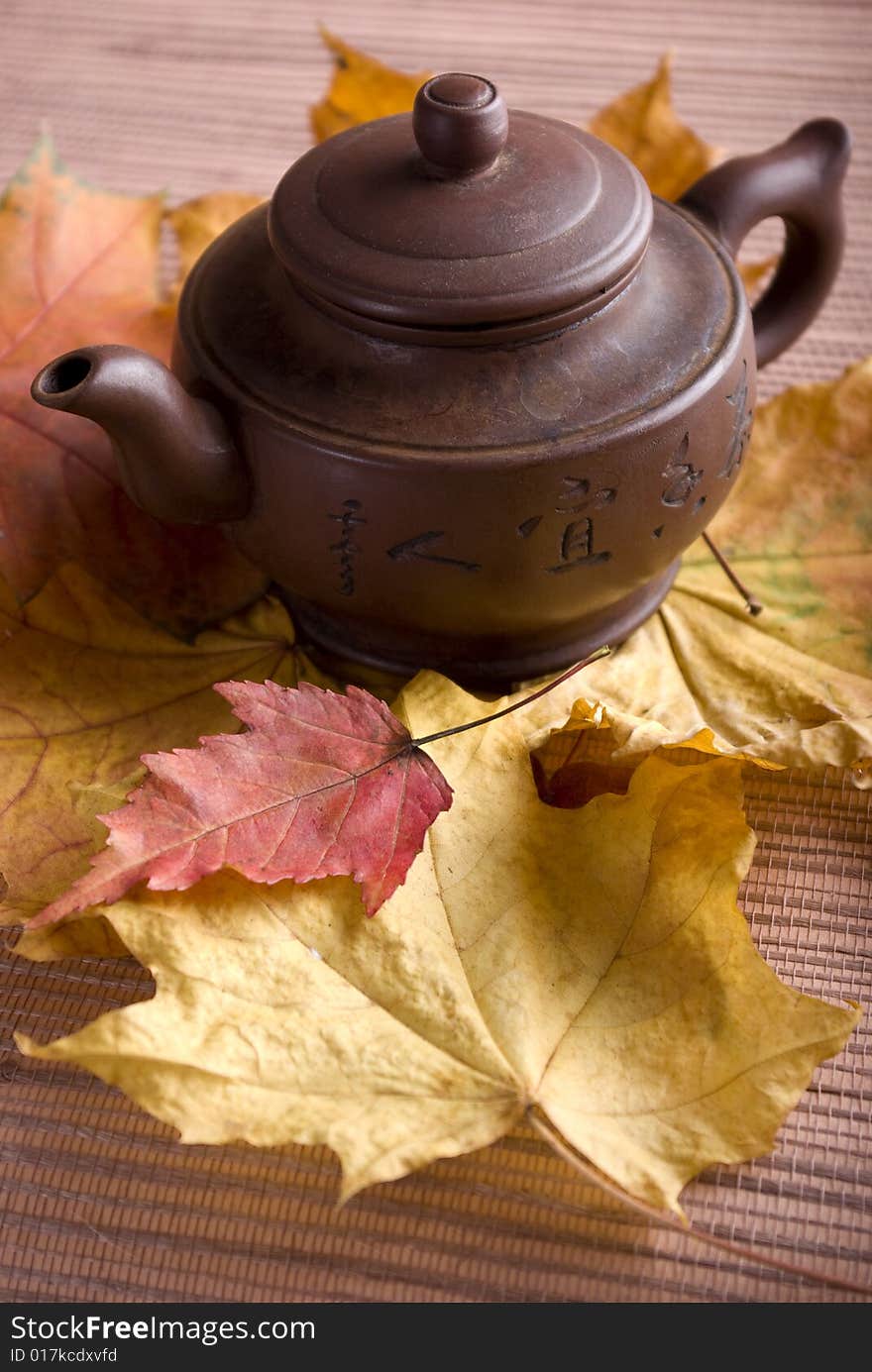 Tea pot on the yellow and red leafs. Tea pot on the yellow and red leafs.