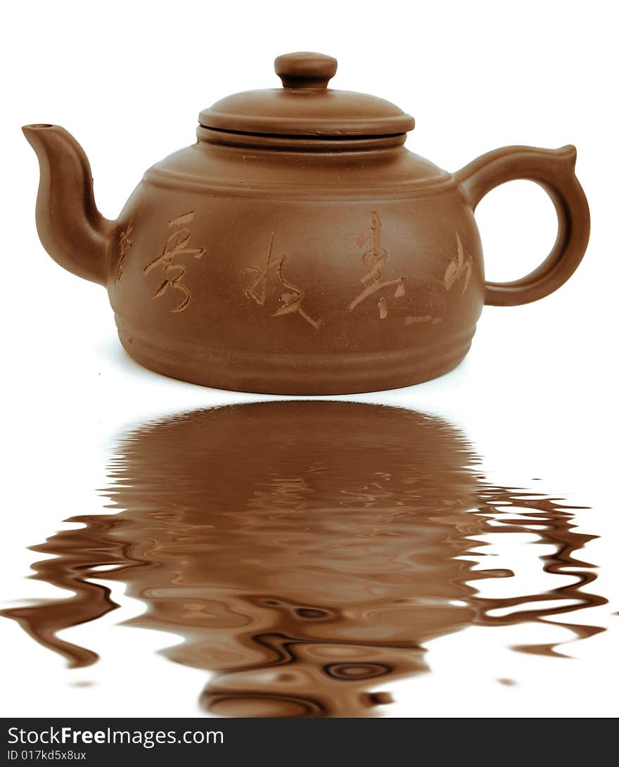 Classic chinese teapot of brown clayand reflection in water