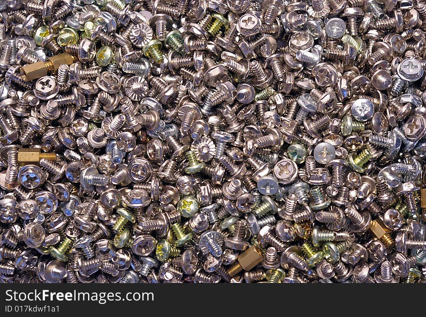 A lot of computer screws as background