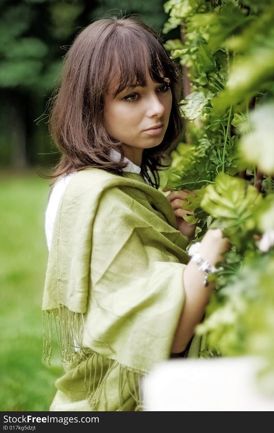 The young woman standing near the wicker fence. The young woman standing near the wicker fence