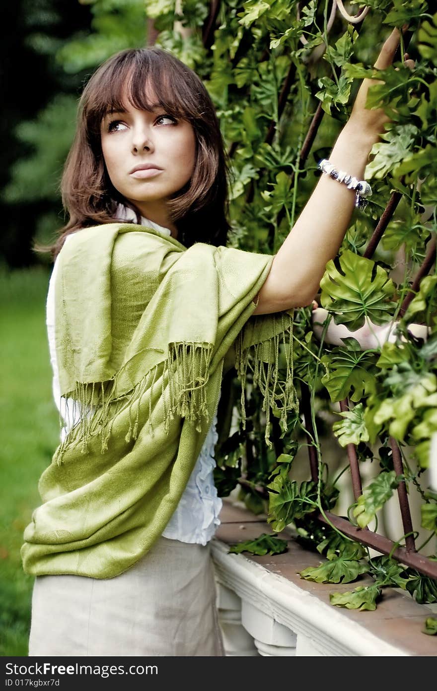 The young woman standing near the wicker fence. The young woman standing near the wicker fence